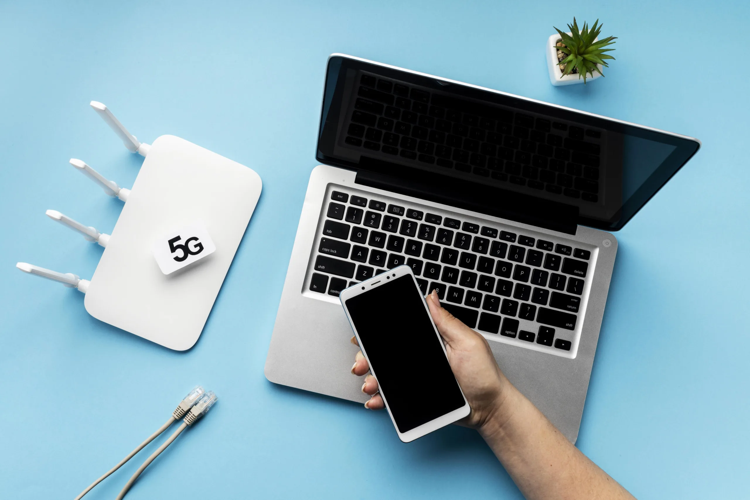 Laptop, smartphone, and Wi-Fi router symbolising better Wi-Fi for business and fixing slow connections.