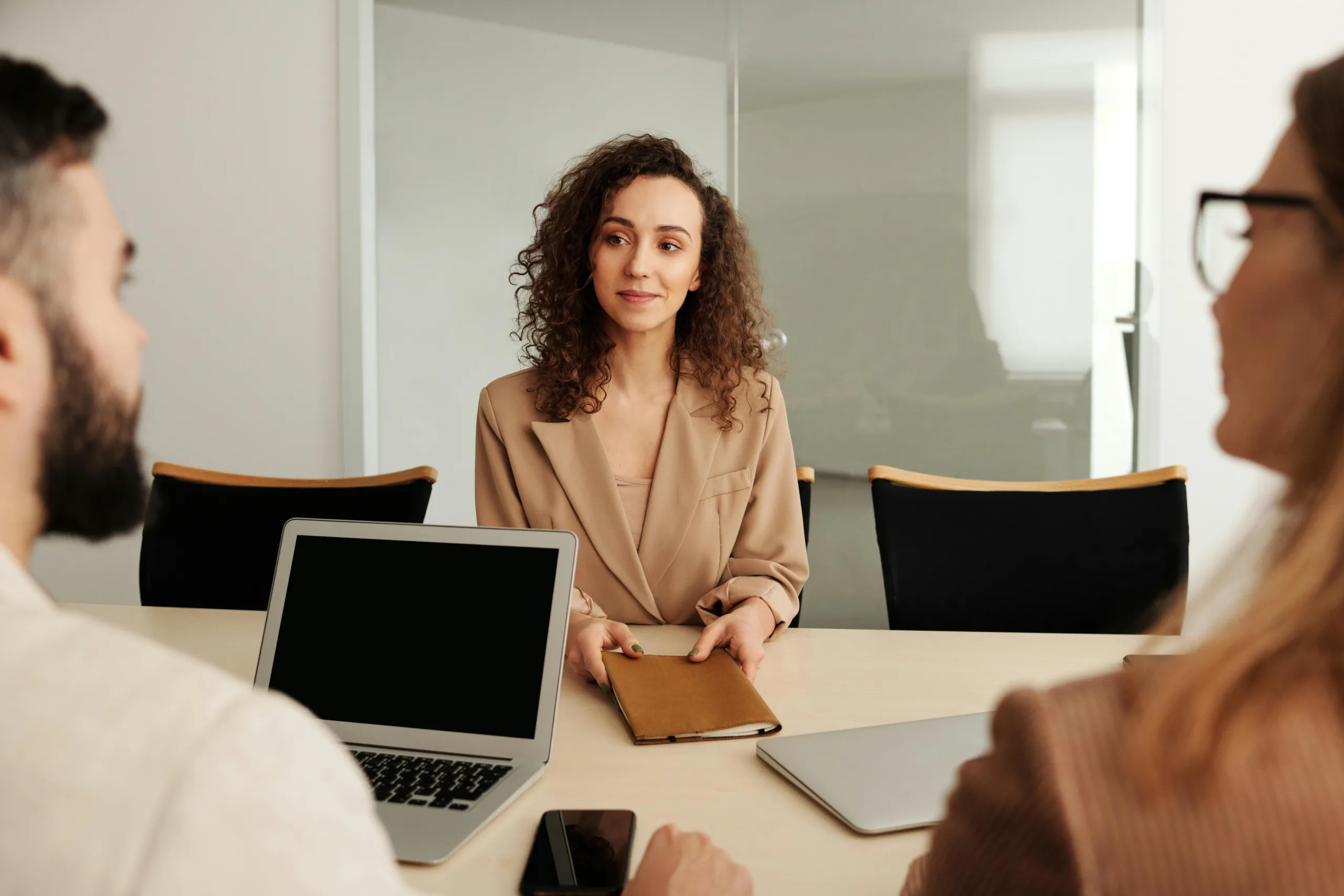 Woman attending a job interview with two people in a modern office