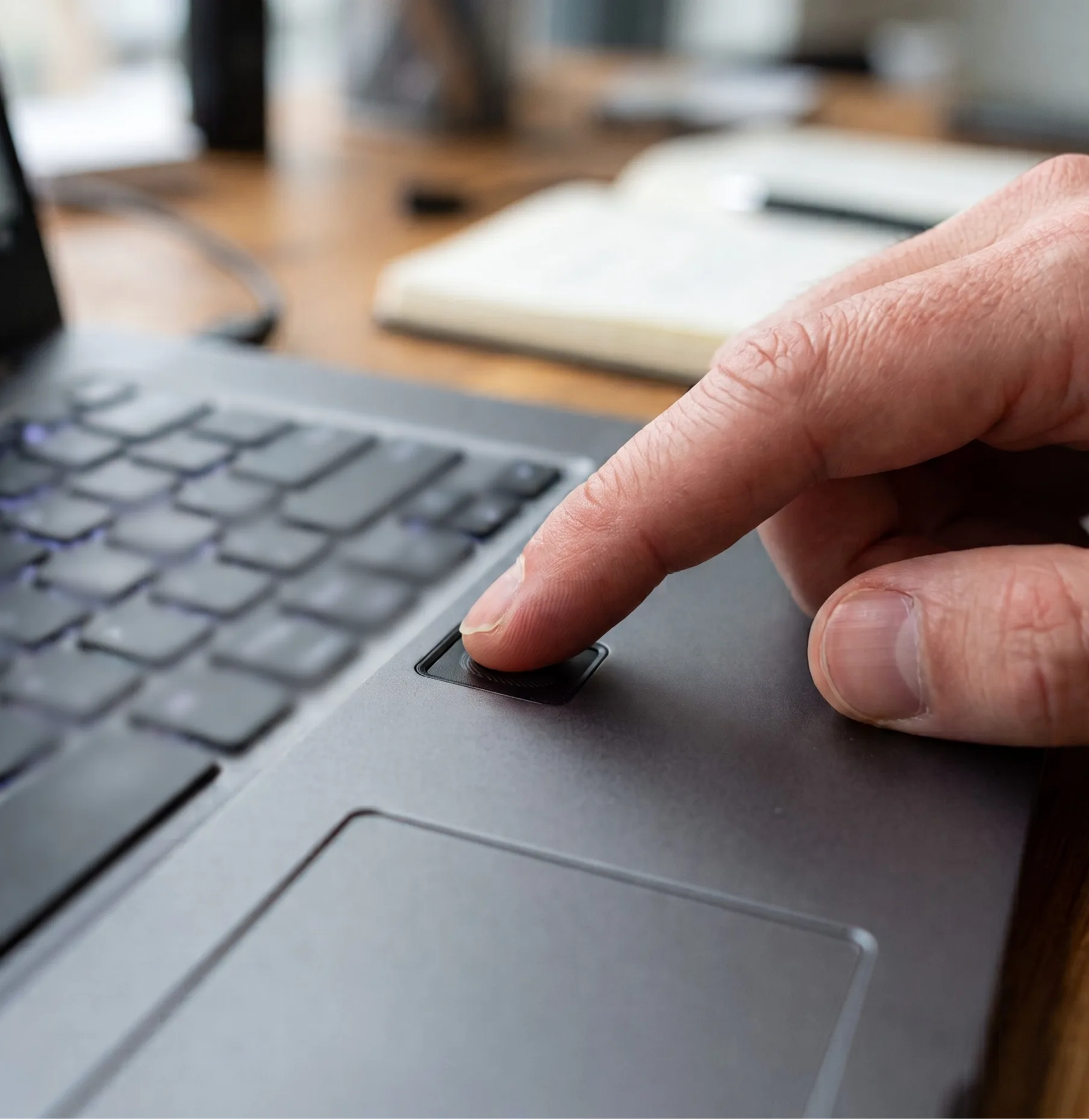 Person using a laptop fingerprint sensor for secure passwordless authentication.